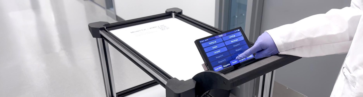 A lab technician selecting a destination on the Model C2 touchscreen