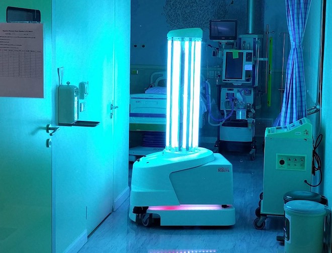 UV light disinfecting autonomous mobile robot (AMR) sanitizing a hospital patient room with UV light