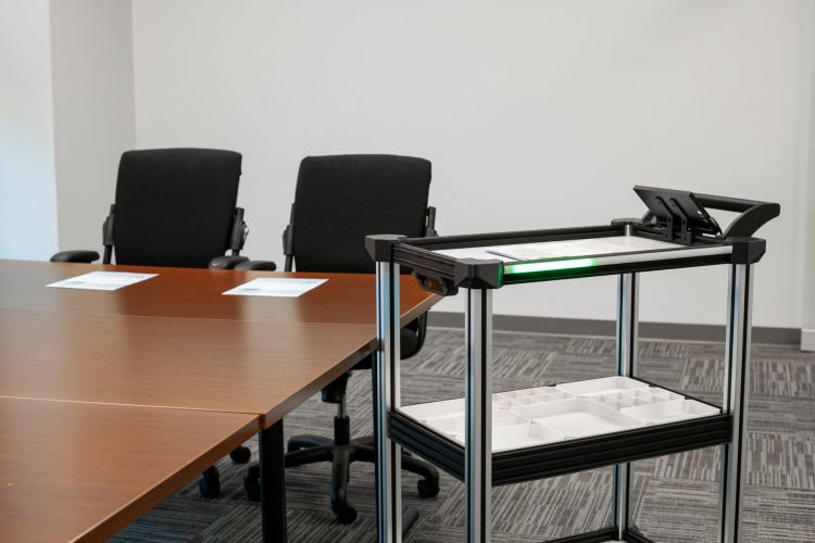 Model C2 Autonomous Delivery Cart completes material transport of supplies to an office conference table.