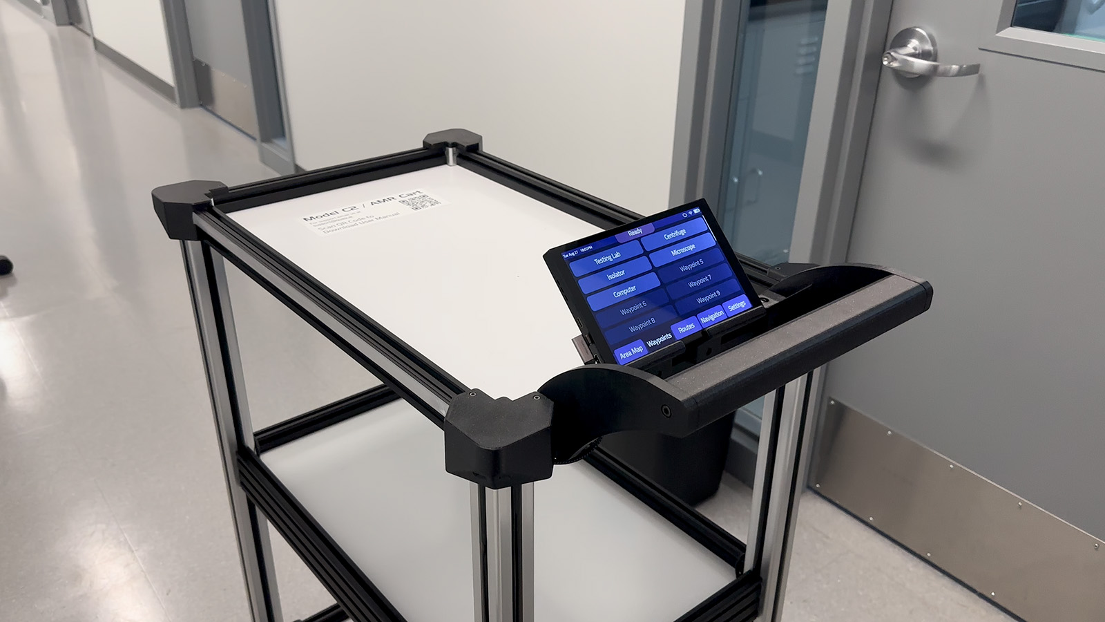 Model C2 in a lab hallway with its onboard touchscreen showing the waypoint menu