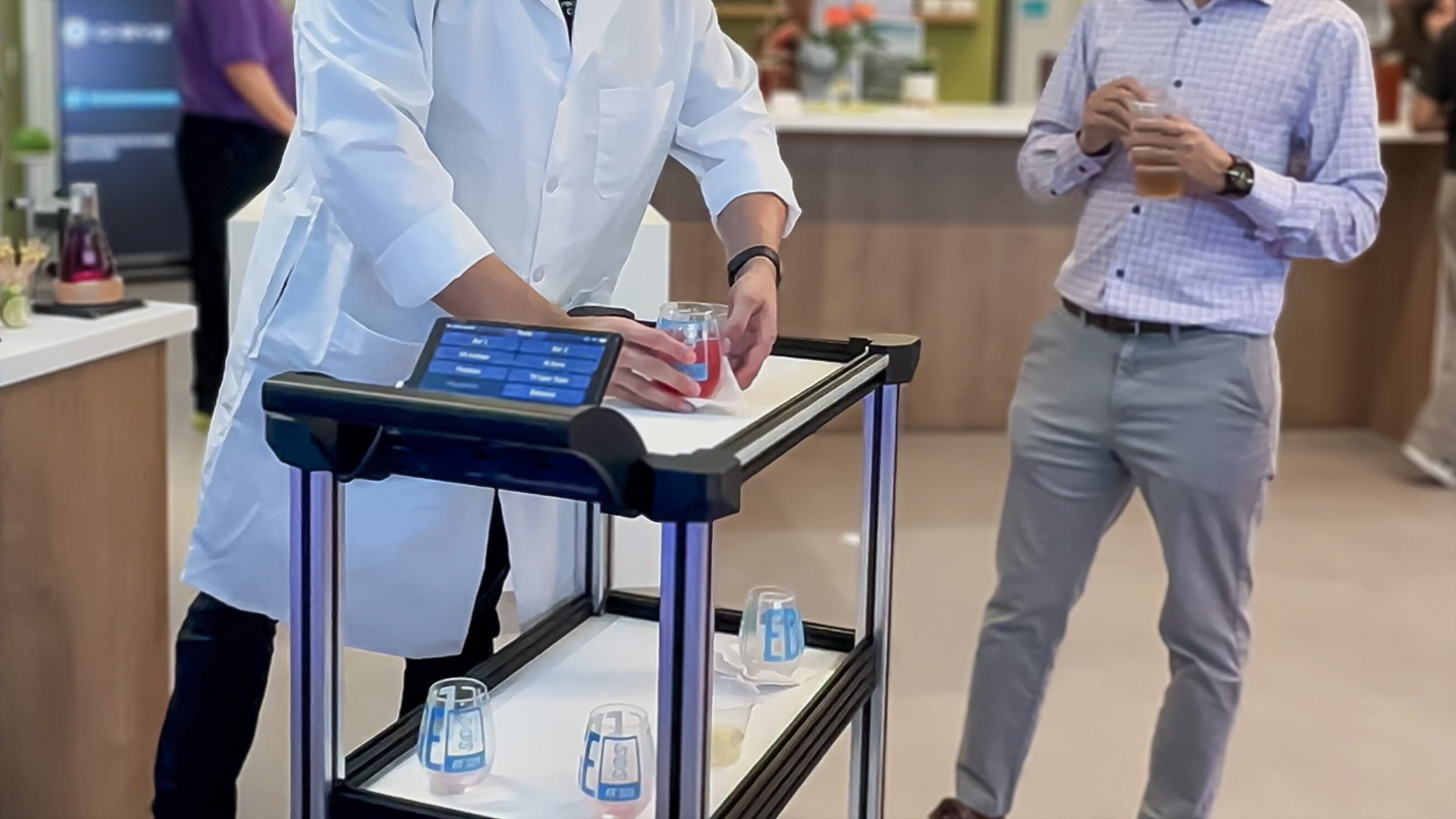 c2 service environment Model C2 autonomous robotic delivery cart being loaded with a drink by a bartender at an industry event.