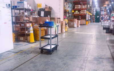 C2 autonomous delivery cart driving through manufacturing floor with blue crate on top shelf