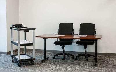 Model C2 autonomous cart in an office environment with docs reviewing reviewing AMR vendor questions during a delivery robot evaluation